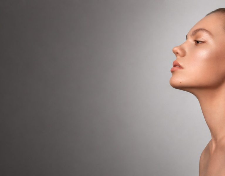 Mulher de perfil com pele iluminada e aparência natural, representando tratamentos estéticos faciais da Bellaris Clinic em Santa Catarina.